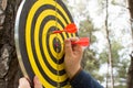 Little girl hands removed the arrows from dart board in the park