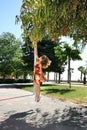 Little girl hanging by branch.