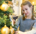 Little girl hanging decorative ball.