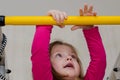 Little girl hanging on horizontal bar Royalty Free Stock Photo