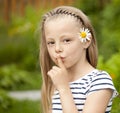 Little girl has put forefinger to lips as sign of silence Royalty Free Stock Photo