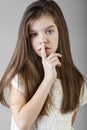 Little girl has put forefinger to lips as sign of silence Royalty Free Stock Photo