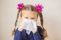 The little girl has a runny nose and blows her nose into a paper Royalty Free Stock Photo
