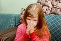 Little girl has a runny nose and blows her nose into a paper handkerchief Royalty Free Stock Photo