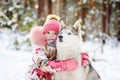 Little girl and hasky dog together in winter park