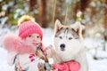 Little girl and hasky dog together in winter park