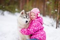 Little girl and hasky dog together in winter park