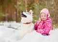 Little girl and hasky dog together in winter park