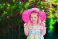 Little girl in a hat in blooming summer garden Royalty Free Stock Photo