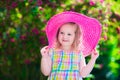 Little girl in a hat in blooming summer garden Royalty Free Stock Photo