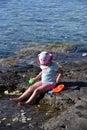 Little girl with a hat playing on the beach Royalty Free Stock Photo