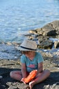 Little girl with a hat playing on the beach Royalty Free Stock Photo