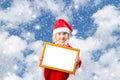 Little girl in hat of Santa Claus on background of sky Royalty Free Stock Photo