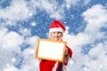 Little girl in hat of Santa Claus on background of sky Royalty Free Stock Photo