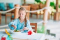 Adorable little girl having dinner at outdoor cafe Royalty Free Stock Photo