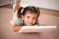 Little girl having fun in her bedroom. Lying on floor Royalty Free Stock Photo