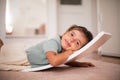 Little girl having fun in her bedroom. Lying on floor Royalty Free Stock Photo