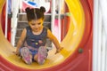 A little girl having fun inside colorful plastic tunnel at playground area