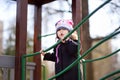 Little girl having fun on outdoor playground on spring or autumn day