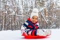 little girl having fun and sledding sled playing in snowy park