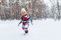little girl having fun and sledding sled playing in snowy park
