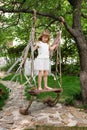 Little girl having fun on a swing outdoor. Child playing, garden playground. Royalty Free Stock Photo