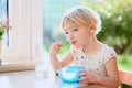 Little girl having oatmeal for breakfast Royalty Free Stock Photo