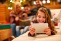 little girl with headphones lying and using a tablet on Christmas day.