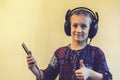 Little Girl Headphones Using Phone. thumbs up. toned Royalty Free Stock Photo
