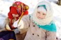 Little girl in a headscarf in the Russian style, with a wooden s