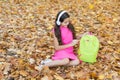 Little girl in headset open backpack, autumn