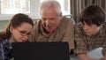 Little girl help her grandpa to type on laptop