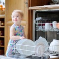 Little girl helping with dish washing machine Royalty Free Stock Photo