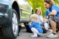 Little girl helping father to change a car wheel Royalty Free Stock Photo