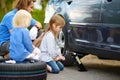 Little girl helping father to change a car wheel Royalty Free Stock Photo