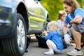 Little girl helping father to change a car wheel Royalty Free Stock Photo