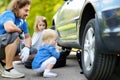 Little girl helping father to change a car wheel Royalty Free Stock Photo