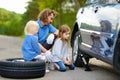 Little girl helping father to change a car wheel Royalty Free Stock Photo