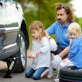 Little girl helping father to change a car wheel Royalty Free Stock Photo