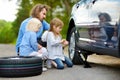 Little girl helping father to change a car wheel Royalty Free Stock Photo