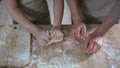Little girl helping grandmother to roll dough for pizza, family recipe, cooking Royalty Free Stock Photo