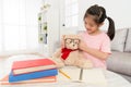 Little girl helping her bear toy wearing glasses Royalty Free Stock Photo