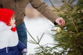 Little girl helping her father decorating Christmas three outdoor.