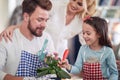 A little girl helping her father to plant a flowers at home. Family, home, playtime