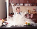 Little girl is helping to bake in a messy kitchen