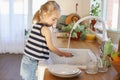 A little girl helps to wash the dishes Royalty Free Stock Photo