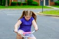 little girl with her bicycle A 5 year old girl is riding a bike on a path through a park Royalty Free Stock Photo