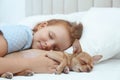 Little girl with her Chihuahua dog in bed. Childhood pet Royalty Free Stock Photo