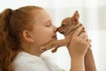 Little girl with her Chihuahua puppy indoors. Baby animal