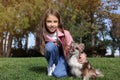 Little girl with her cute dog in park. Autumn walk Royalty Free Stock Photo